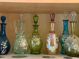 de nombreux vases en verre de différentes couleurs posés sur une étagère