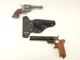 un vieux pistolet et un étui posés sur une surface blanche