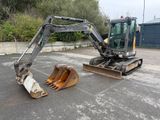 a small excavator that is sitting in the parking lot