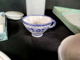 a blue and white bowl sitting on a table next to other dishes