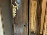 a wooden armoire with a mirror and a chair