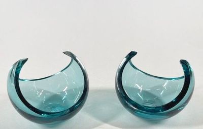 two pieces of blue glass sitting on a white surface