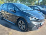 une voiture noire garée sur un parking, avec d'autres voitures en arrière-plan