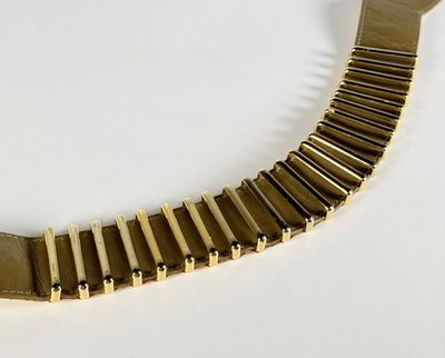 un bracelet en or posé sur une surface blanche