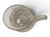 a glass cup with a handle on a white surface