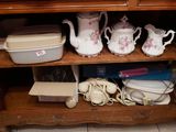 une étagère en bois sur laquelle sont posés tout un tas d'assiettes et de tasses