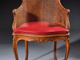 une vieille chaise sur laquelle est posé un coussin rouge