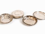 quatre assiettes plaquées argent sur un fond blanc