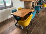 tables and chairs in a room with a fireplace in the background