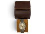 an image of a watch sitting on top of a brown leather case