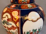 a blue and red vase with a bird and flowers on it