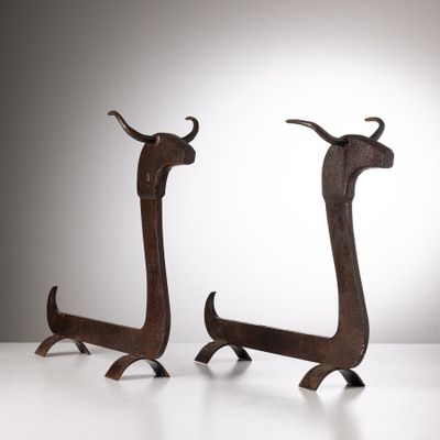 deux sculptures métalliques représentant des bovins à longues cornes, posées sur une surface blanche avec un fond gris