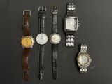 Plusieurs montres différentes sont alignées sur une surface noire
