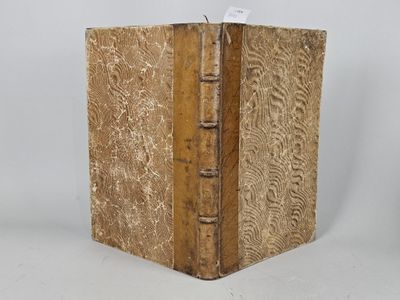 an old book with a wooden cover on a white surface