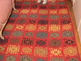 une femme assise sur un tapis dans une pièce