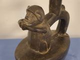 a wooden statue of a monkey on a boat on a blue table