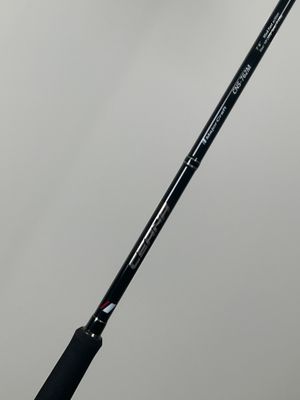 a close up of a black and white fishing rod on a gray background