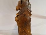 an old wooden statue of a man holding a baby in his arms