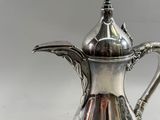 an antique silver plated coffee pot on a white background