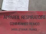 une pancarte posée par terre sur laquelle on peut lire : « appariil resiratire comments relivo »