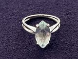 a close up of a ring with a green stone on a purple surface