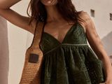 Le mannequin porte un haut vert et un pantalon kaki.