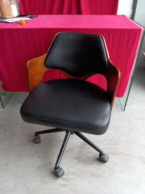 a black office chair sitting in front of a red table