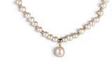 a close up of a necklace with pearls and a gold ball