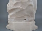 a white vase with a bird on top of it