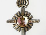 a cross with a crown on it hanging on a wall