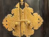 a black cabinet with a gold decoration on the door