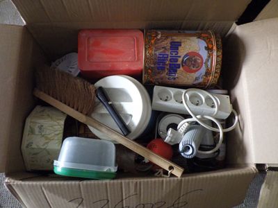 une boîte en carton remplie d'objets hétéroclites sur le sol