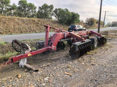 an image of a tractor plow parked on the side of the road