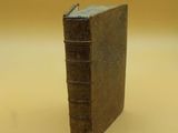 an old book sitting on top of a table next to a white table