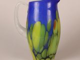 a blue and yellow pitcher with a green design on it