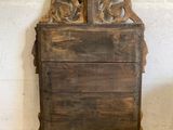 an old wooden chest of drawers sitting against a white brick wall