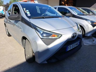 des voitures garées les unes à côté des autres sur un parking devant un immeuble