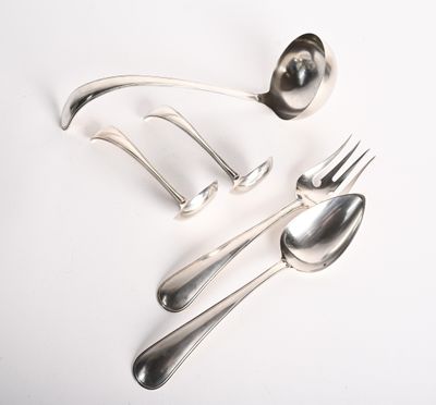 une cuillère, une fourchette et un repose-cuillère posés sur une surface blanche