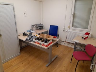 a room with a desk, a chair, and a printer