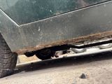 a cat that is sitting under a car on the street