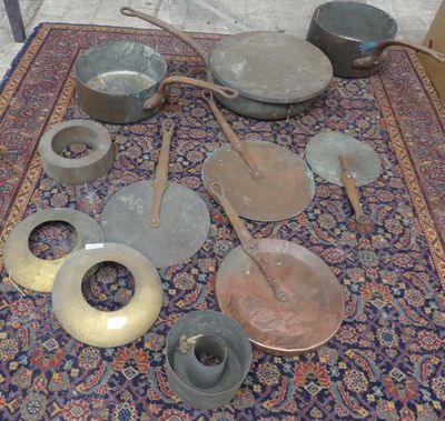 de nombreuses casseroles et poêles posées sur un tapis, par terre
