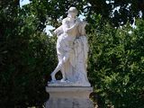 a statue in the middle of a park with trees in the background