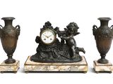 trois vases et une horloge posés sur une table