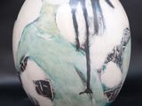 a white vase with a black and white design on it