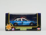 une voiture de police miniature dans une boîte posée sur une table