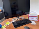 un bureau sur lequel se trouvent un ordinateur, un clavier, une souris et d'autres objets