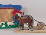 a toy horse pulling a sleigh with a picture frame in the background