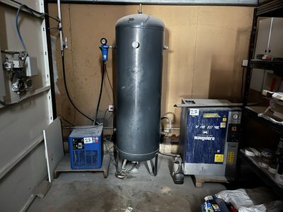 a water heater in a garage next to a trash can