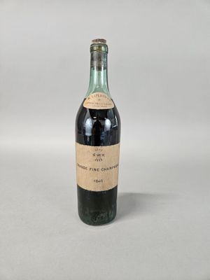 une vieille bouteille de vin posée sur une table blanche
