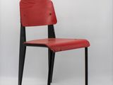 red chair with black legs against a white background